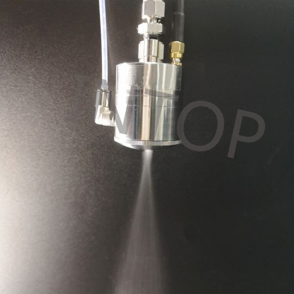 Ultrasonic spray nozzle atomizing liquid