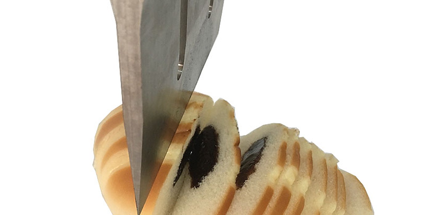 Food Cutting application &mdash; an ultrasonic blade slicing a loaf of bread cleanly, with no crumbs or squashing