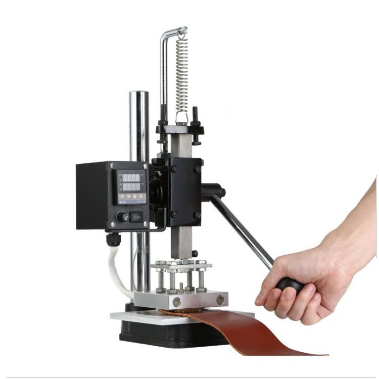 Heated die being pressed onto leather by hand