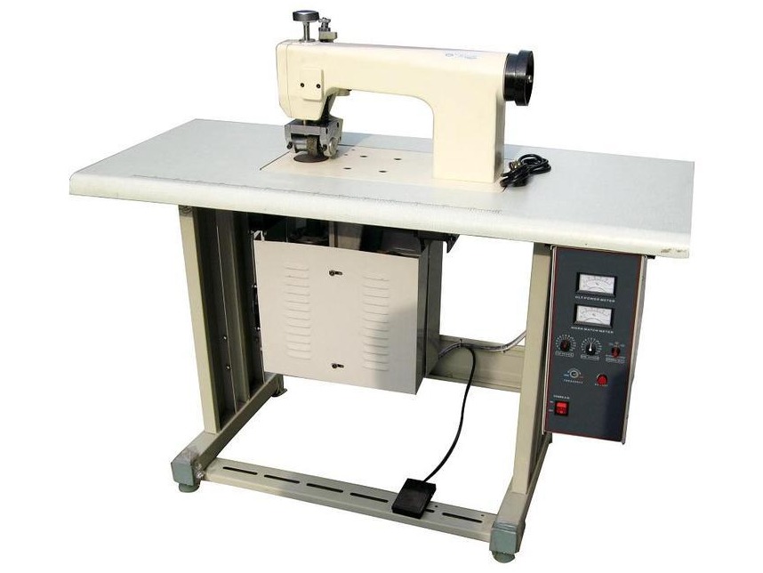Ultrasonic lace sewing machine on a working table with generator panel and foot pedal