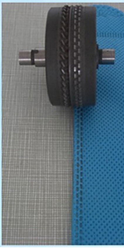 Pattern roller welding a lace edge along blue non-woven fabric
