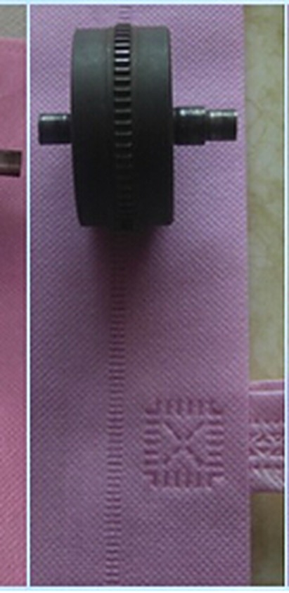 Embossed pattern rows welded into pink non-woven fabric