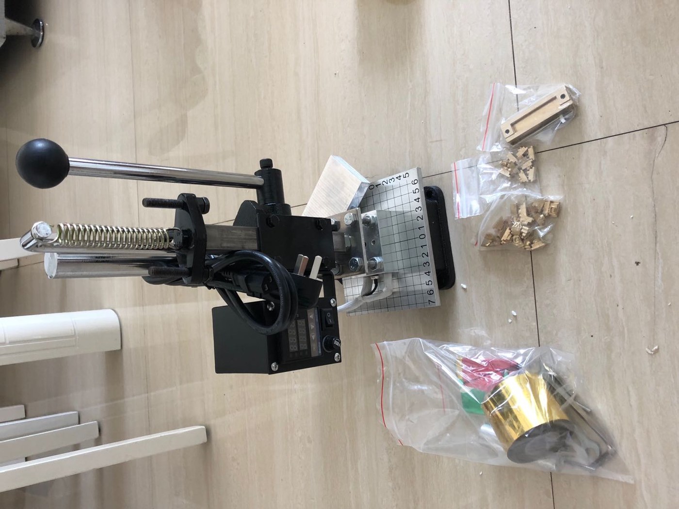 Hot stamping press with dies and work on the bench